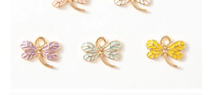 Detailed macro view of colorful enamel dragonfly pendants with golden frames for jewelry DIY