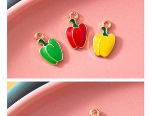 Macro detail of colorful bell pepper pendants in red, yellow and green enamel finish
