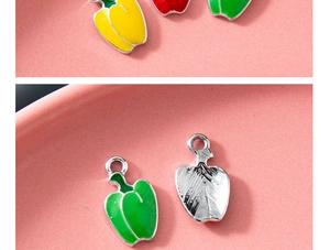 Detail showing the front and back of colorful enamel bell pepper charms with metal hooks