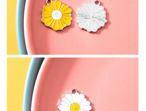 Detailed macro view of enamel daisy charms showing front flower petals and silver metal back