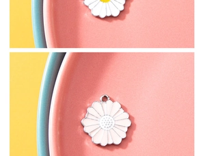 Macro shot of white and pink daisy flower pendants in a ceramic plate for DIY jewelry