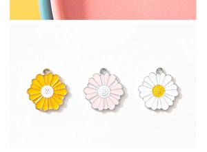 Detailed macro view of colorful daisy flower charms in yellow, pink, and white enamel