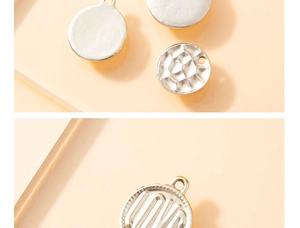 Detailed view of silver alloy disc charms with LOVE engraving and hammered metal textures