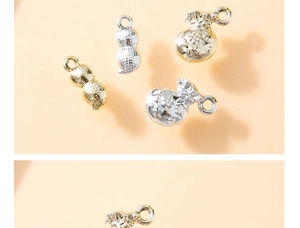 Detailed macro of gold and silver peanut and fortune bag charms with refined engraving