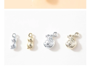 Detail of gold and silver lucky bag and peanut pendants with textured metal finish