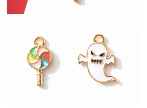 Macro detail of colorful enamel lollipop and white ghost charms for Halloween DIY jewelry