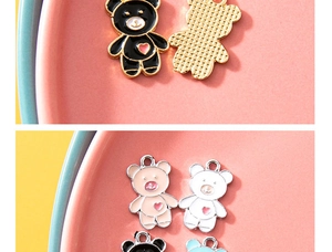 Detalle de dijes de osito de esmalte de colores con corazones rosas y reverso dorado pulido