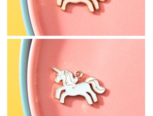 Vue détaillée des pendentifs licorne avec émail coloré et bords plaqués or
