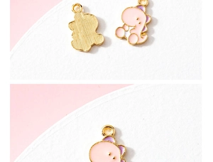 Vue macro de breloques dinosaures en émail rose et violet avec bords dorés pour bijoux DIY