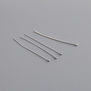 Macro detail of four polished silver-tone ball pins for DIY jewelry making and beading