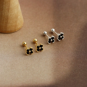 Macro shot of S925 sterling silver clover stud earrings with black stones and screw balls