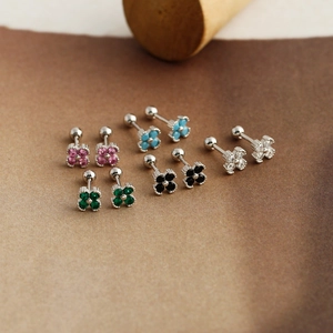 Detailed view of colorful zircon flower screw back stud earrings on brown cardstock