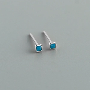 Detail view of square S925 silver stud earrings with turquoise blue cubic zirconia stones
