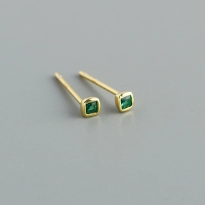 Close-up of small square green zircon stud earrings with elegant gold plating detail