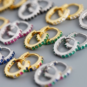 Détail de boucles d'oreilles huggies en argent S925 serties de zircons colorés