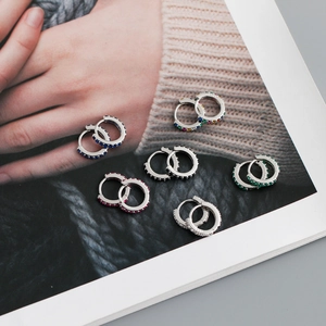 Lot de six boucles d'oreilles huggie en argent S925 avec zircons colorés sur magazine