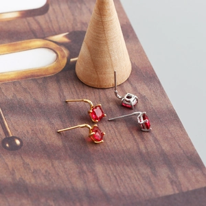 Macro shot of square-cut red zircon earrings with 4-prong gold and silver settings