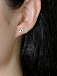 Macro-opname van minimalistische vergulde S925 zilveren evil eye oorknop met groene zirkoon