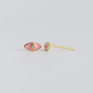 Macro-opname van goudkleurige evil eye oorknopjes met roze emaille en zirkonia steen