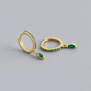 Close-up of gold hoop earrings featuring green marquise gemstones and cubic zirconia pavé