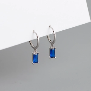Détail de boucle d'oreille en argent S925 avec zircon bleu rectangulaire et poinçon