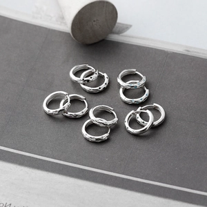 Macro-opname van S925 sterling zilveren oorringen met hamerslagtextuur en gekleurde zirkoon
