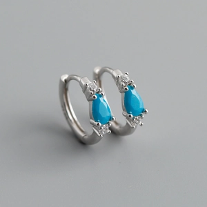 Macro detail of S925 silver hoop earrings with blue pear-shaped zircon stones