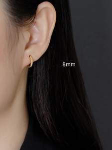 Close-up of 8mm gold S925 sterling silver hoop earring with dotted texture on model