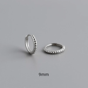 Macro shot of 9mm S925 sterling silver hoop earrings with embossed dotted texture