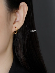 Detail shot of 10mm gold S925 sterling silver hoop earrings with textured dotted surface