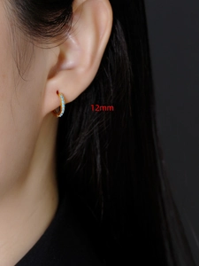 Detailopname van 12mm gouden oorringen met turquoise zirkoon op het model