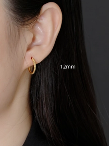 Close-up of 12mm S925 sterling silver beaded hoop earring on earlobe with gold finish