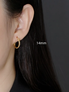 Macro detail of 14mm S925 sterling silver gold-plated hoop earring with bead texture