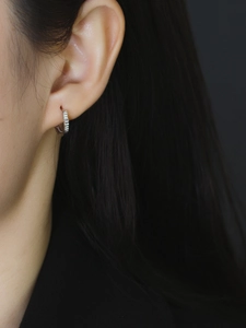 Primer plano de pendientes de aro de plata S925 con textura de rayas verticales