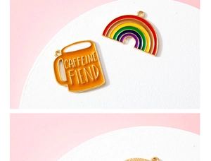Detail van koffiekopje en regenboog emaille bedeltjes met gouden randen voor DIY