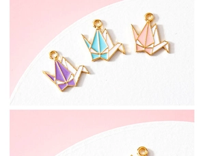 Détail de breloques grues en origami colorées avec bord doré pour création de bijoux