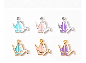 Détail de breloques grues en origami colorées en plaqué or et argent pour bijoux DIY