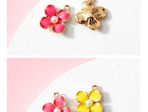 Detailed close-up of pink and yellow enamel flower charms with pearls for DIY jewelry