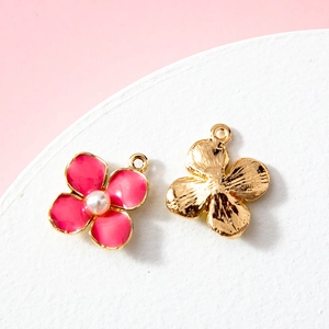 Pink enamel flower pendant with small white pearl and golden metal plating on pink background