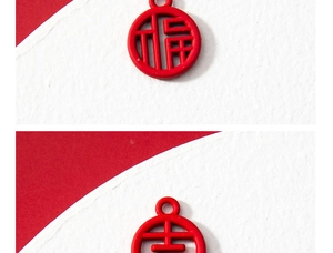 Macro detail of red hollowed-out Fu and Ji Chinese characters alloy charms for DIY jewelry