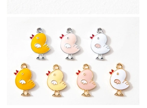Détail de breloques poulet en émail jaune, rose et blanc avec bordure dorée et argentée