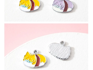 Détail des breloques chat sushi en émail montrant l'avant coloré et le dos en métal brossé
