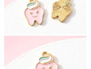 Detail view of cute pink tooth and toothpaste alloy charms for DIY jewelry making