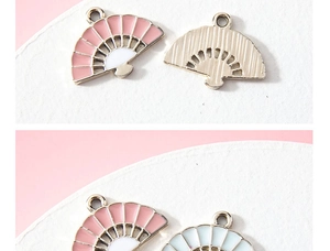 Detailed view of pink and white fan-shaped alloy charms with textured golden metal backing