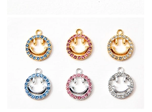 Detailweergave van DIY-smiley-bedeltjes met fonkelende strassteentjes in goud en zilver
