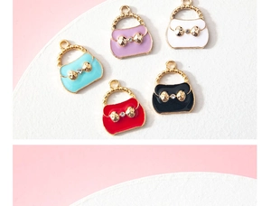 Close-up of enamel handbag pendants with gold bow and crystal for DIY jewelry making