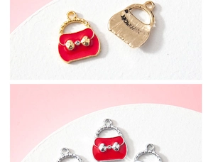 Detailed views of red enamel handbag charms with crystal bows in gold and silver plating