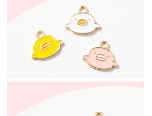 Macro-opname van schattige emaille eendjes voor DIY-sieraden in roze, geel en wit