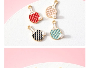 Detailed macro view of colorful enamel table tennis paddle charms with faux pearl accents