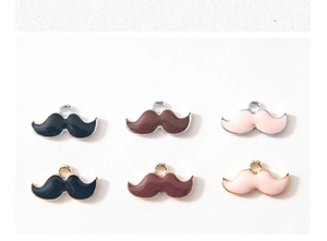 Détail de pendentifs moustaches en alliage avec émail coloré et finition plaquée bicolore